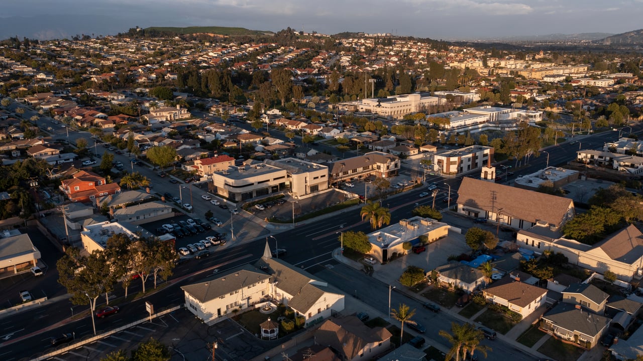 Aerial view of Montebello homes and commercial buildings in warm evening light.