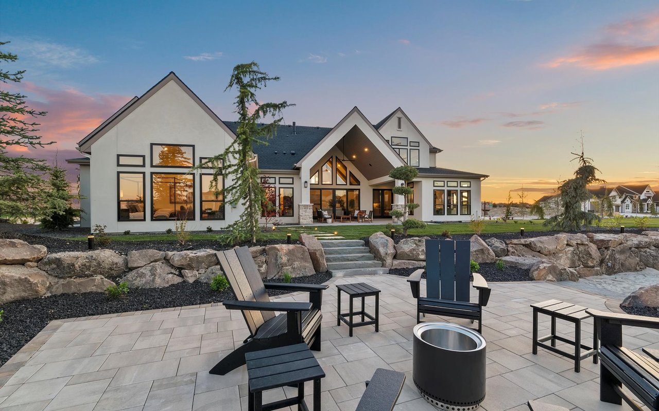 View from the lakeside patio towards the house - pavers, stone retaining wall, and black wood patio furniture