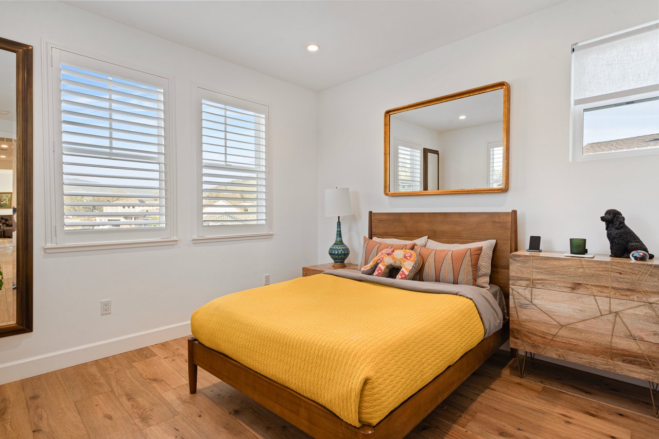 Craftsman-style bedroom with estate shutters and warm oak flooring