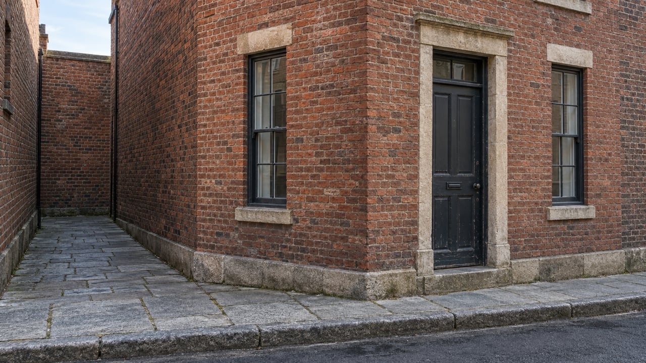 Red-brick street corner with a dark timber door, two narrow sash windows, and a short side passage.