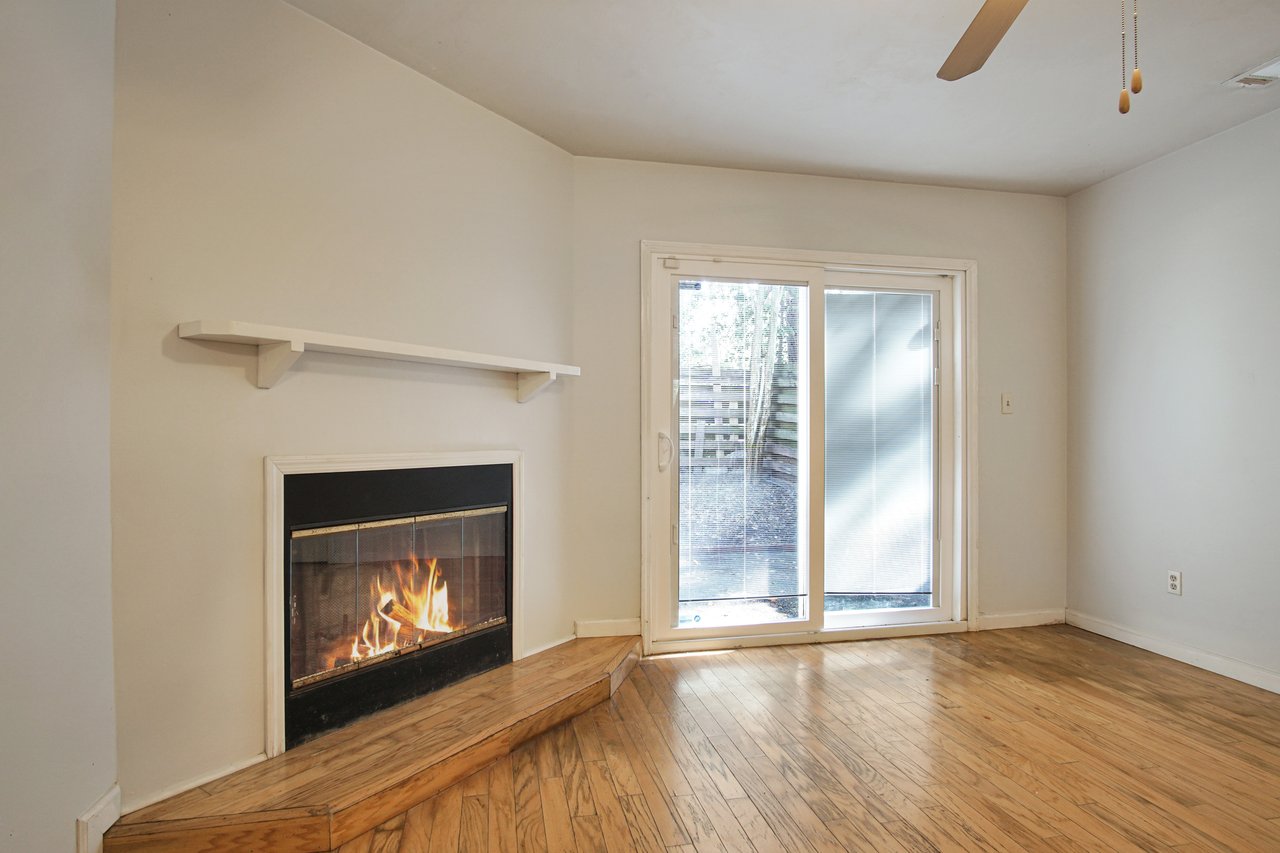 A cozy room featuring a warm fireplace and a sliding door, creating an inviting atmosphere.