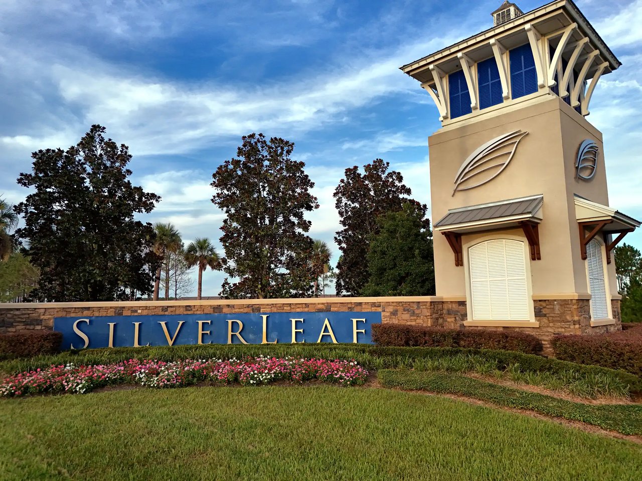 SilverLeaf entrance sign beside a tan tower and landscaped flower bed.