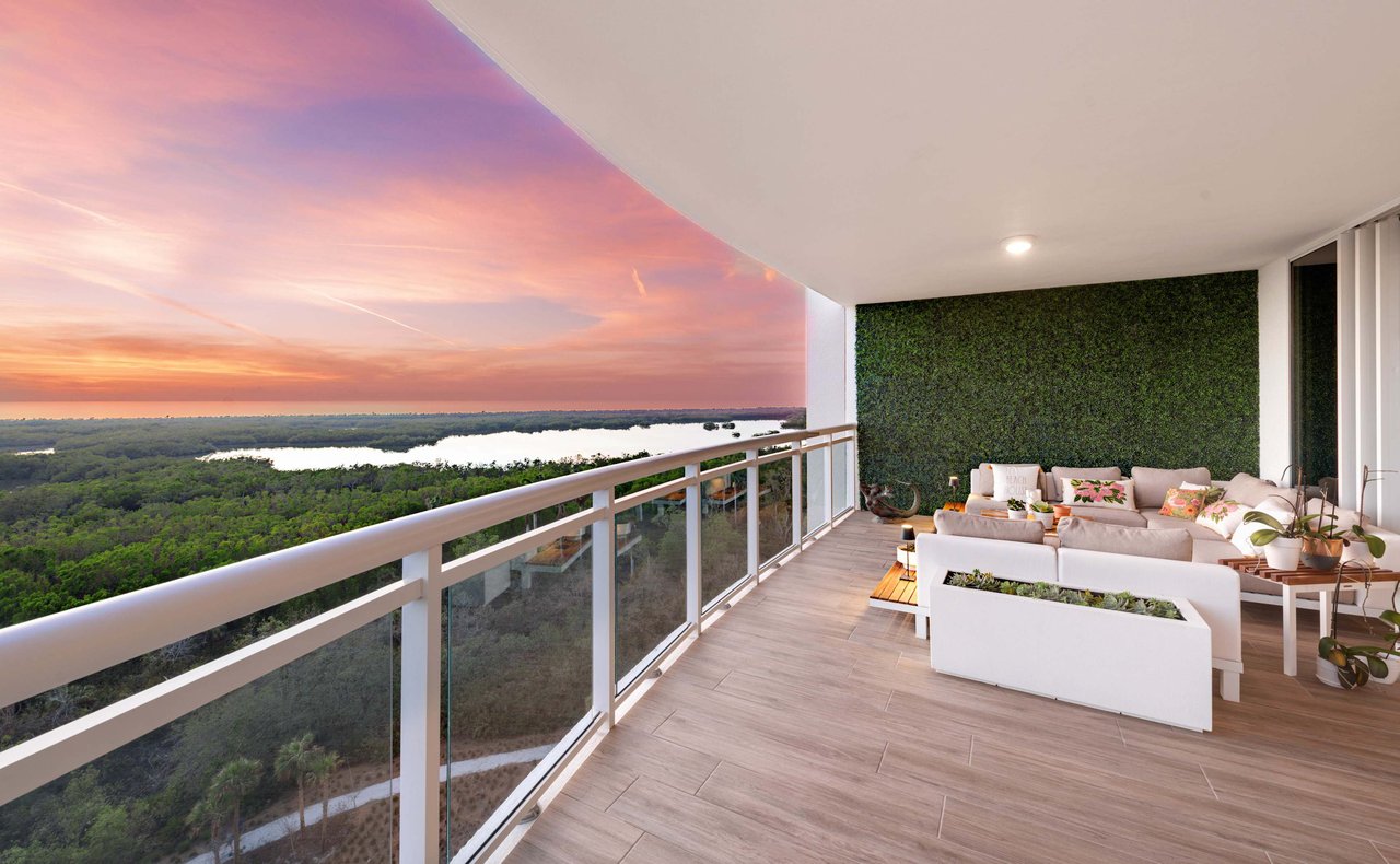  A spacious modern balcony with a glass and white railing.