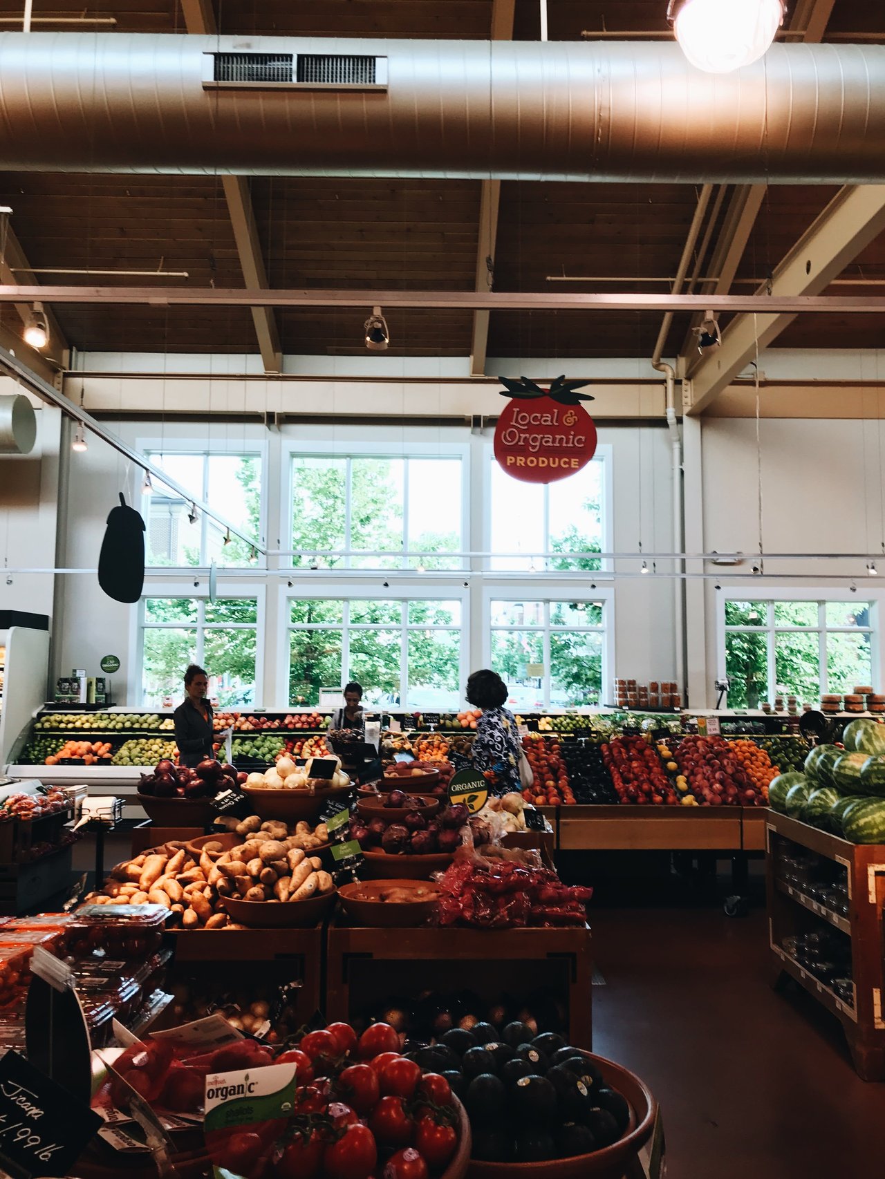 A well-lit grocery store produce section with a variety of fruits and vegetables on display.