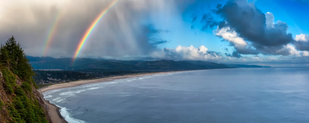 double rainbow and cloudy sky over manzanita Oregon and the Pacificocen