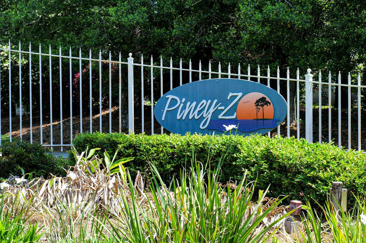 A ground-level view of the entrance sign for "Piney-Z," indicating the name of the residential community.