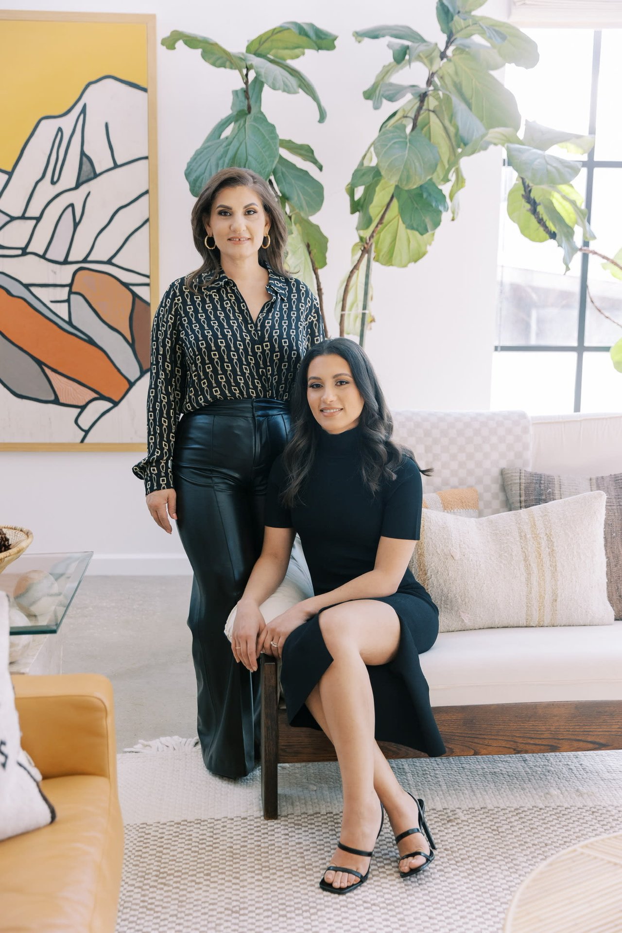 Two Women Wearing Black Top & a Dress