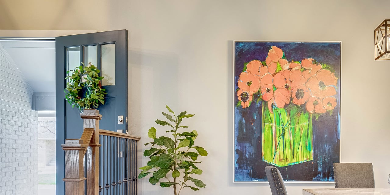 Still life painting of a vase of flowers hanging on a textured wall