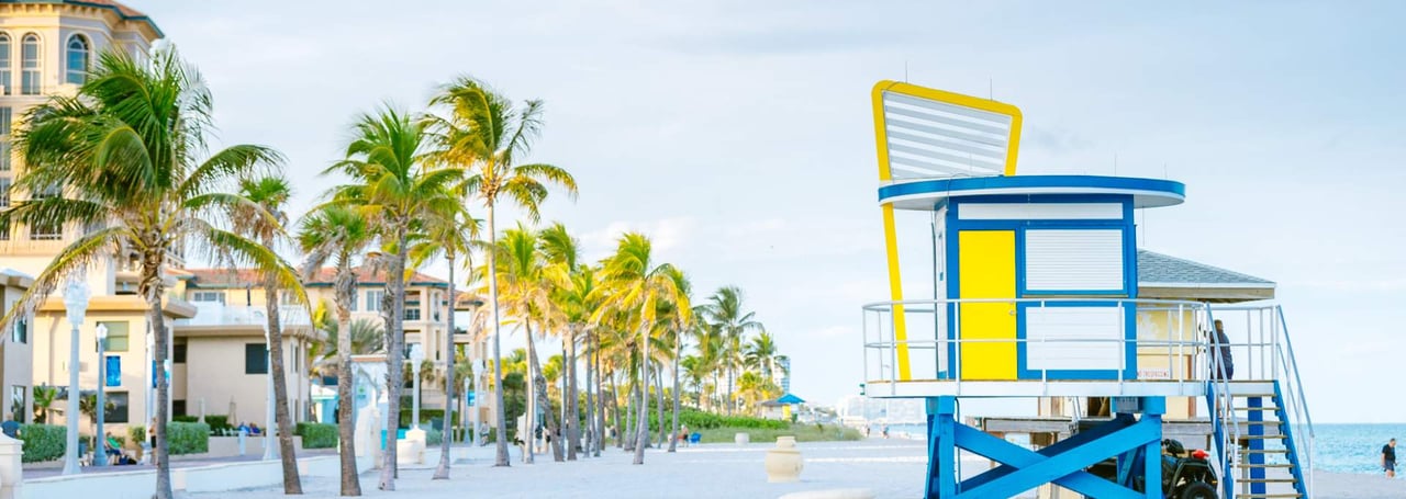 Colorful lifeguard tower with palm trees along Hollywood Beach Broadwalk in Florida.