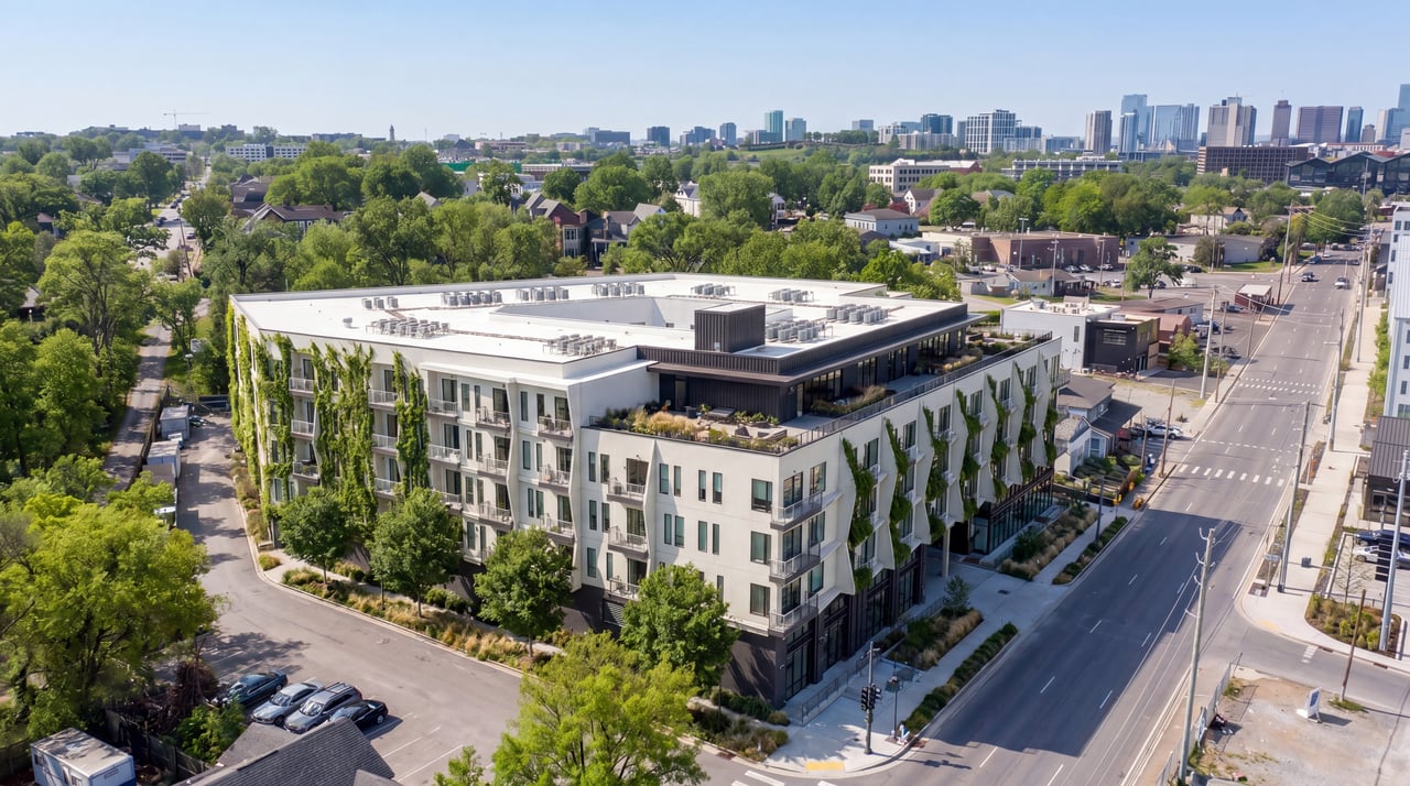 Modern luxury condominium development overlooking the Nashville skyline at sunset, featuring upscale balconies, contemporary architecture, and panoramic downtown city views.