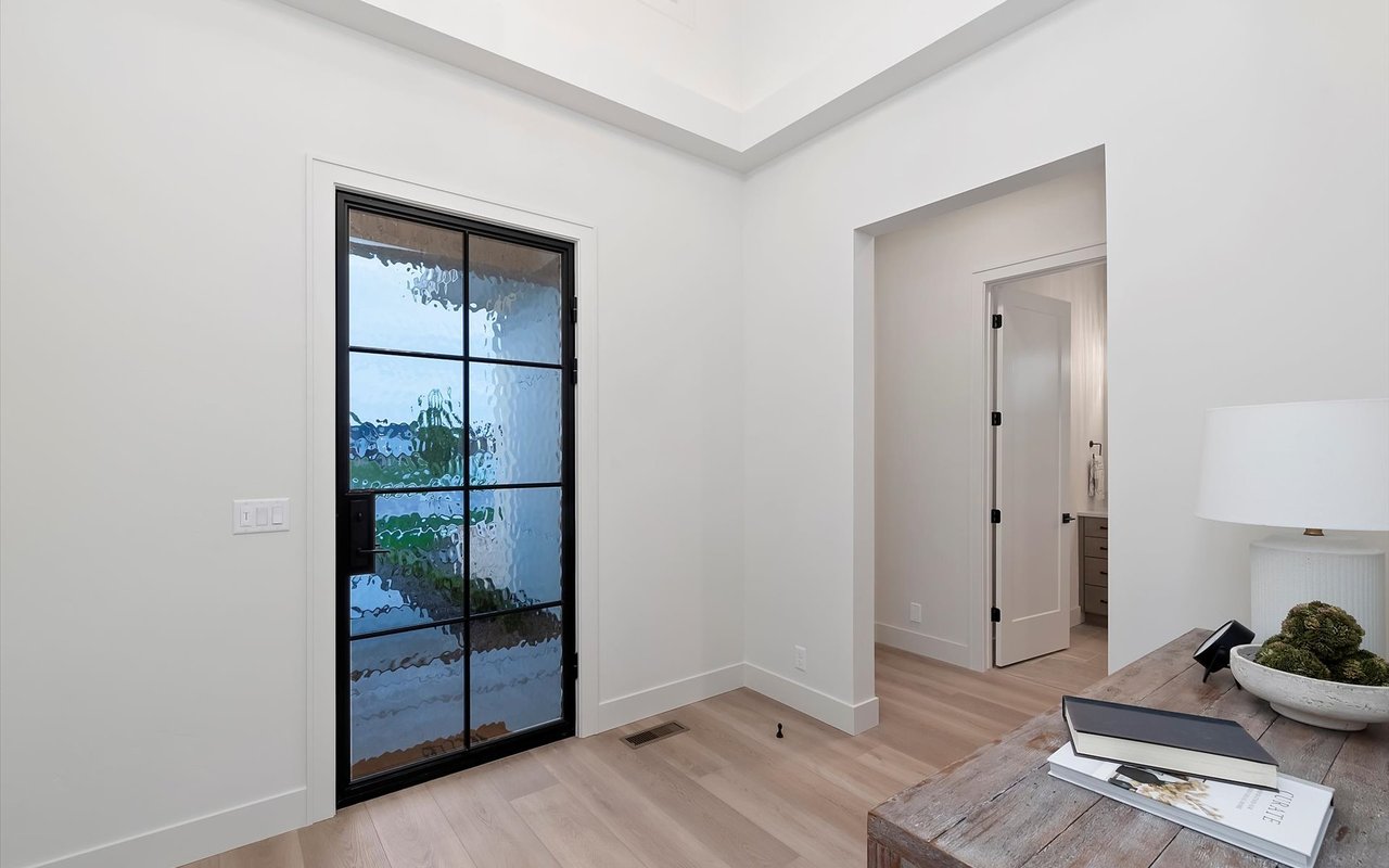 Inside a new modern prairie home. Foyer featuring black steel front door, tray ceilings, white walls, and LVP flooring.