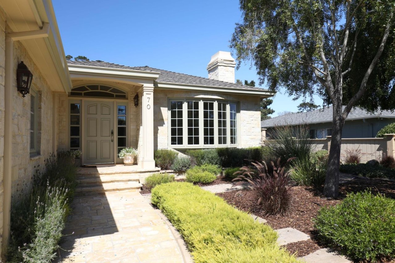 Stone house with a recessed entry, large bay window, and landscaped front walkway.