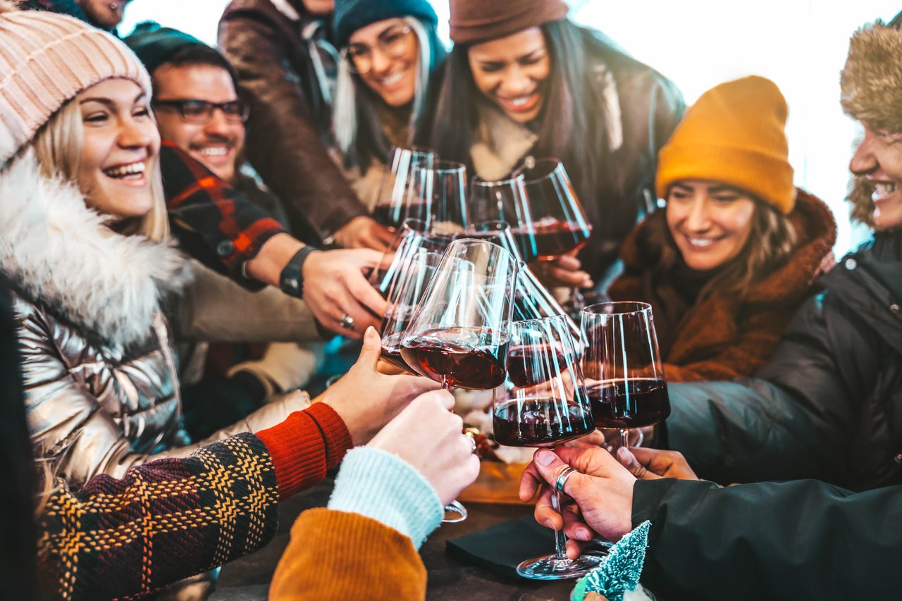 A scenic view of Lake Tahoe with a cozy apres ski setting, including a warm fireplace, cocktails, and mountain backdrop.