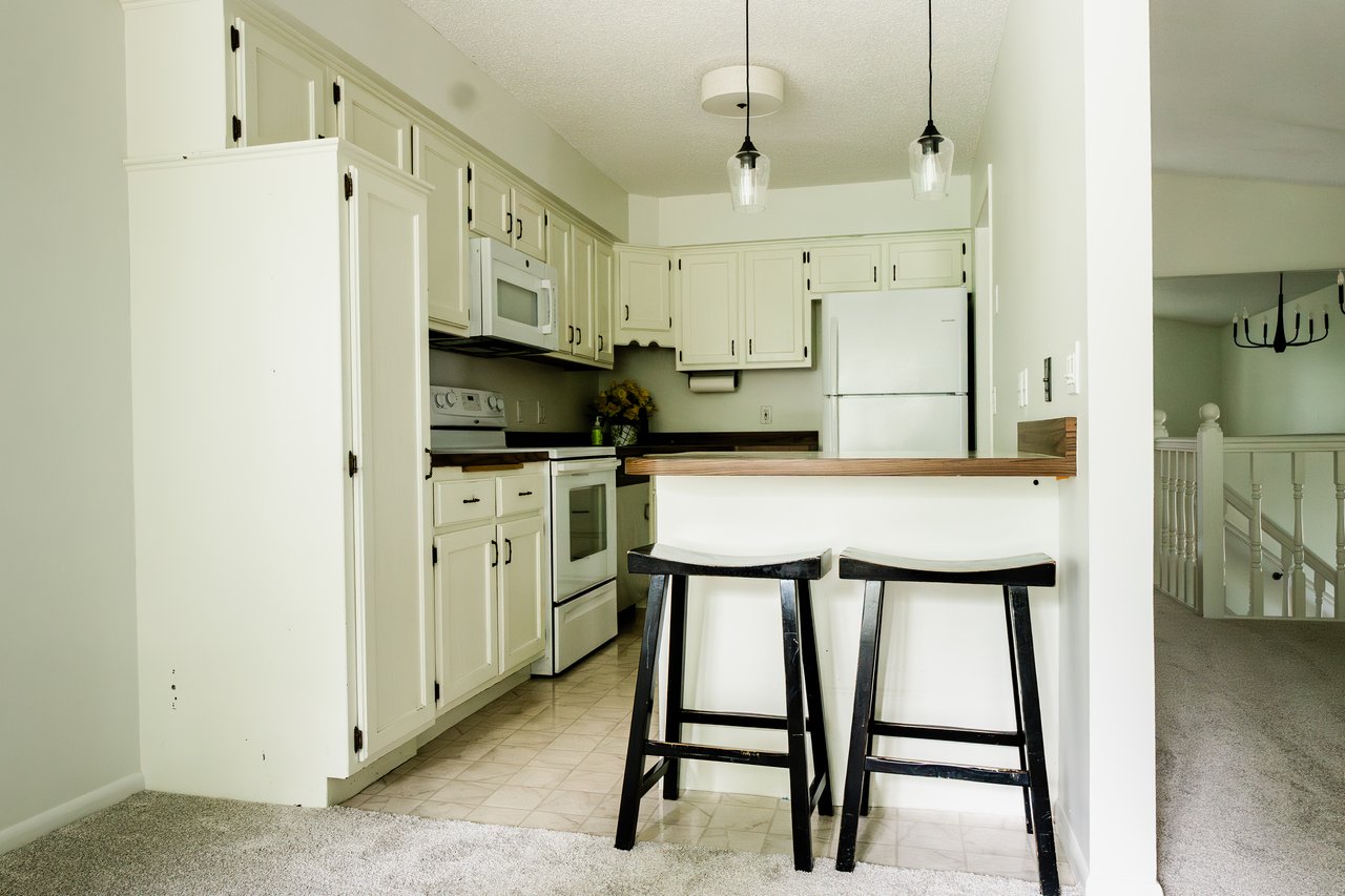 Kitchen includes lots of cabinet storage, new microwave (2026), and an eat-in kitchen island