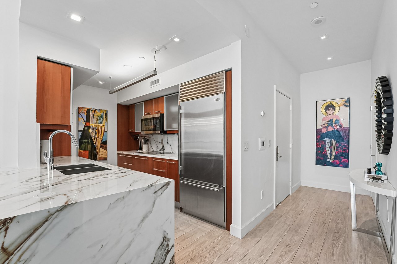 2026-refreshed kitchen with marble-pattern counters and stainless appliances in Jade at Brickell Bay Unit 611