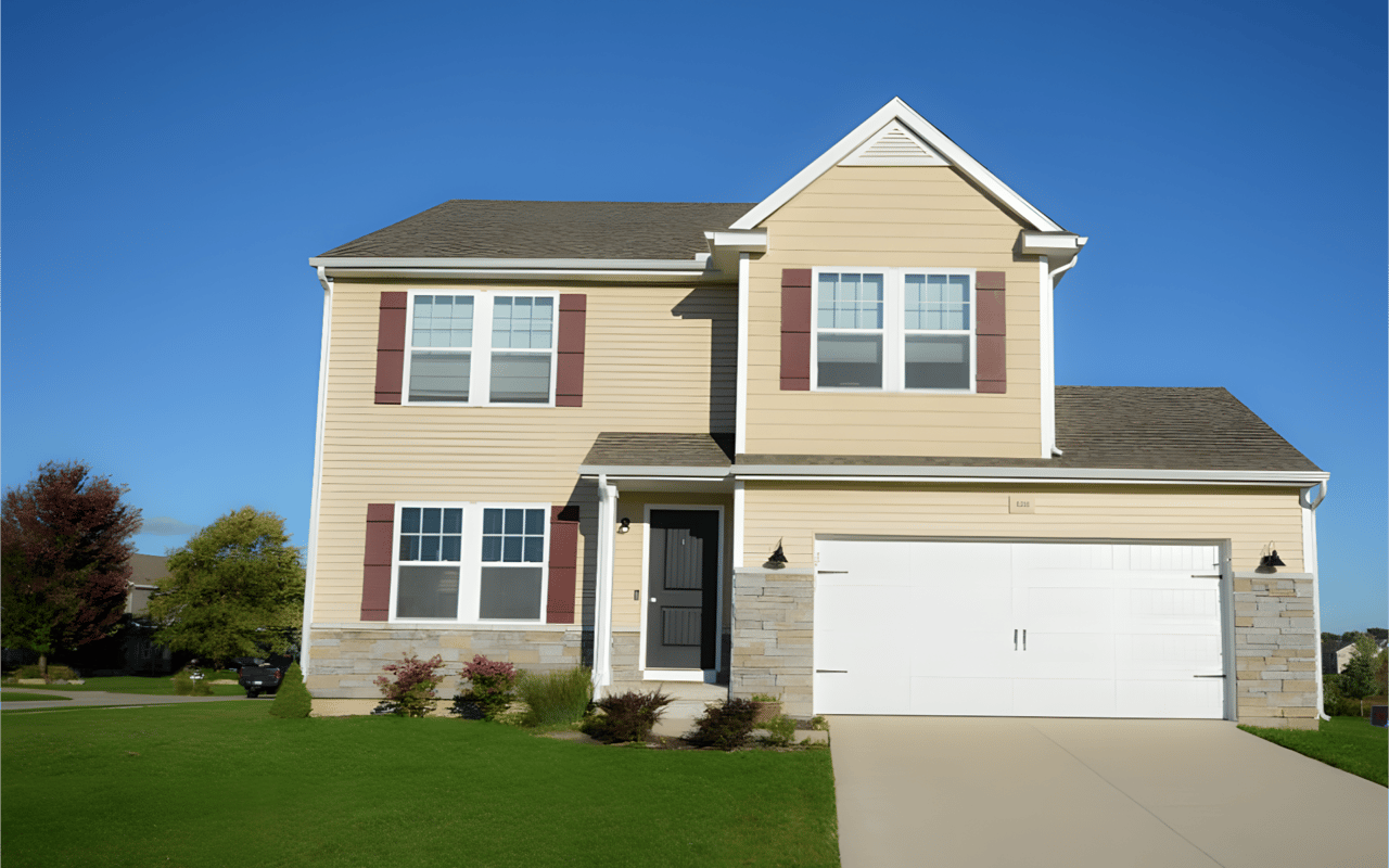Two-story beige house with red shutters, stone accents, and a wide two-car garage.