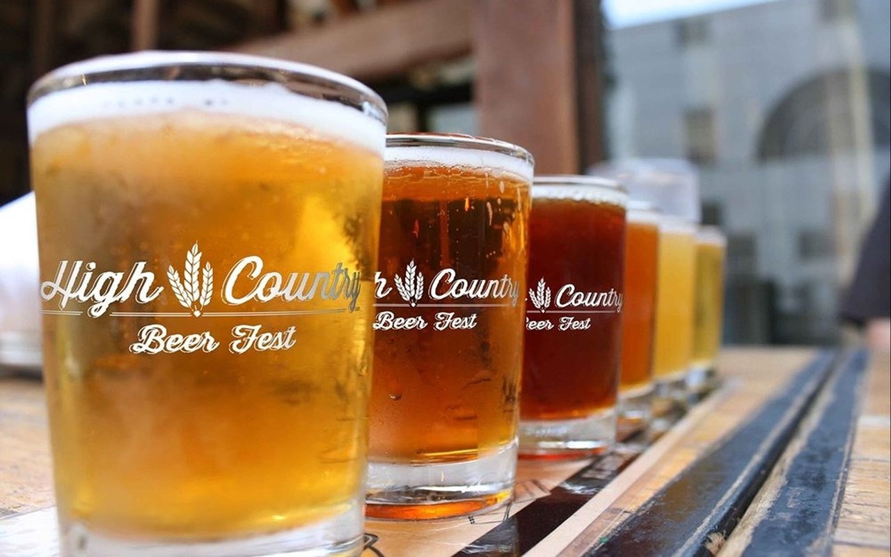 Row of amber and golden beers in glasses branded High Country Beer Fest.