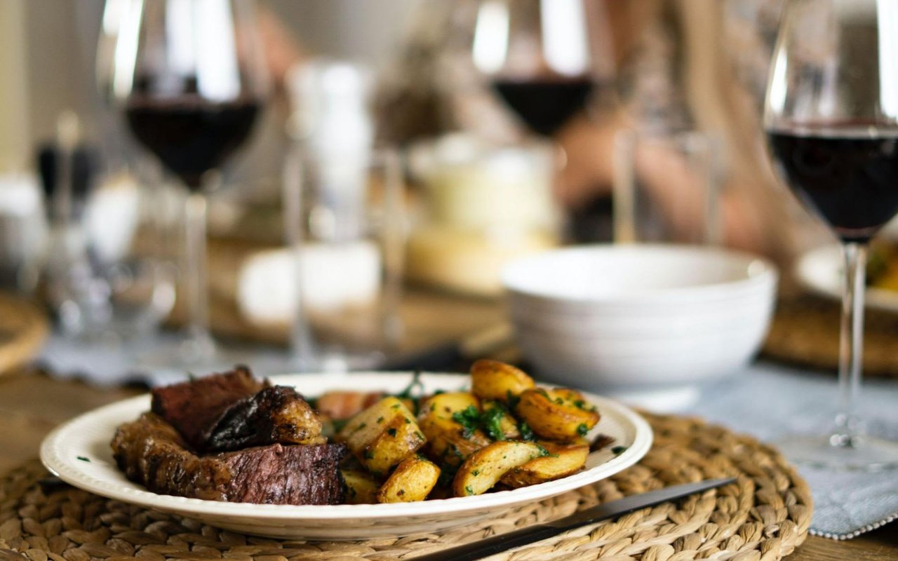 Plate of pasta, red wine, patio dining.