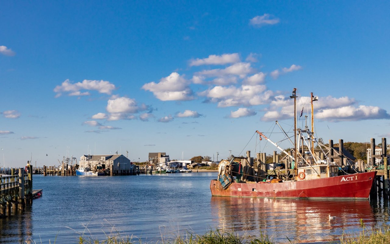 A fishing boat docked in a harbor with clear blue skies