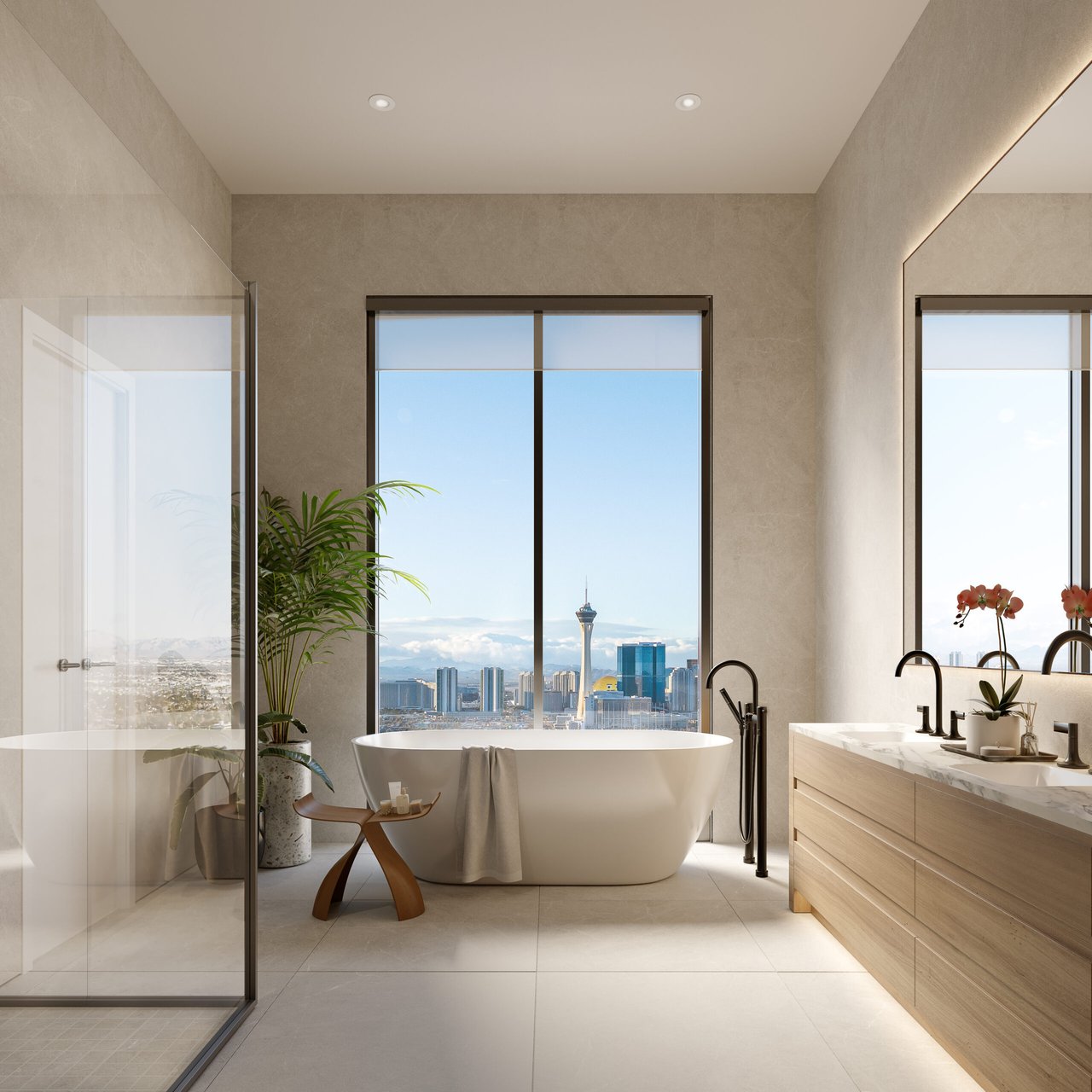Modern condo bathroom with a freestanding tub and Las Vegas skyline views through floor-to-ceiling windows.