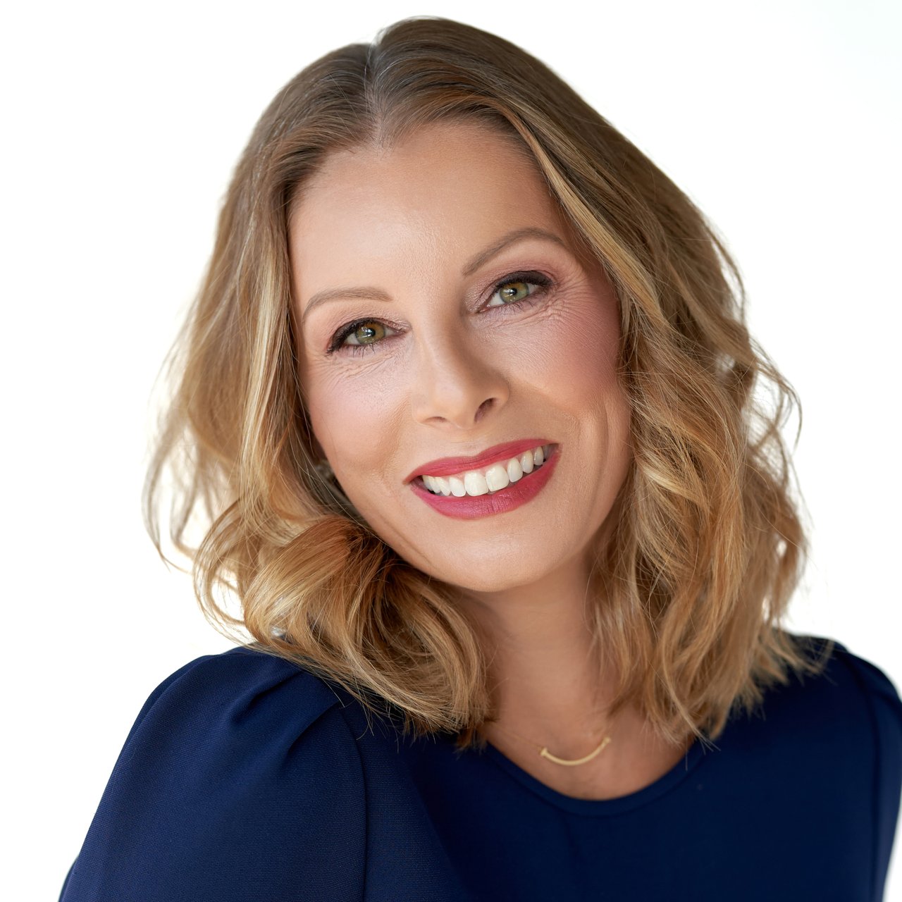 Colleen Stoltz, smiling in a navy top with shoulder-length highlighted hair.