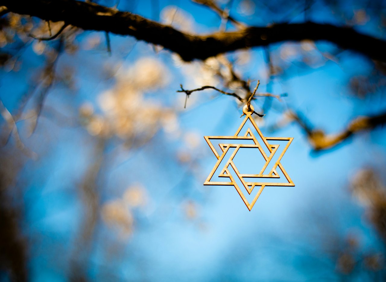 Gold Jewish star of David with blue sky background
