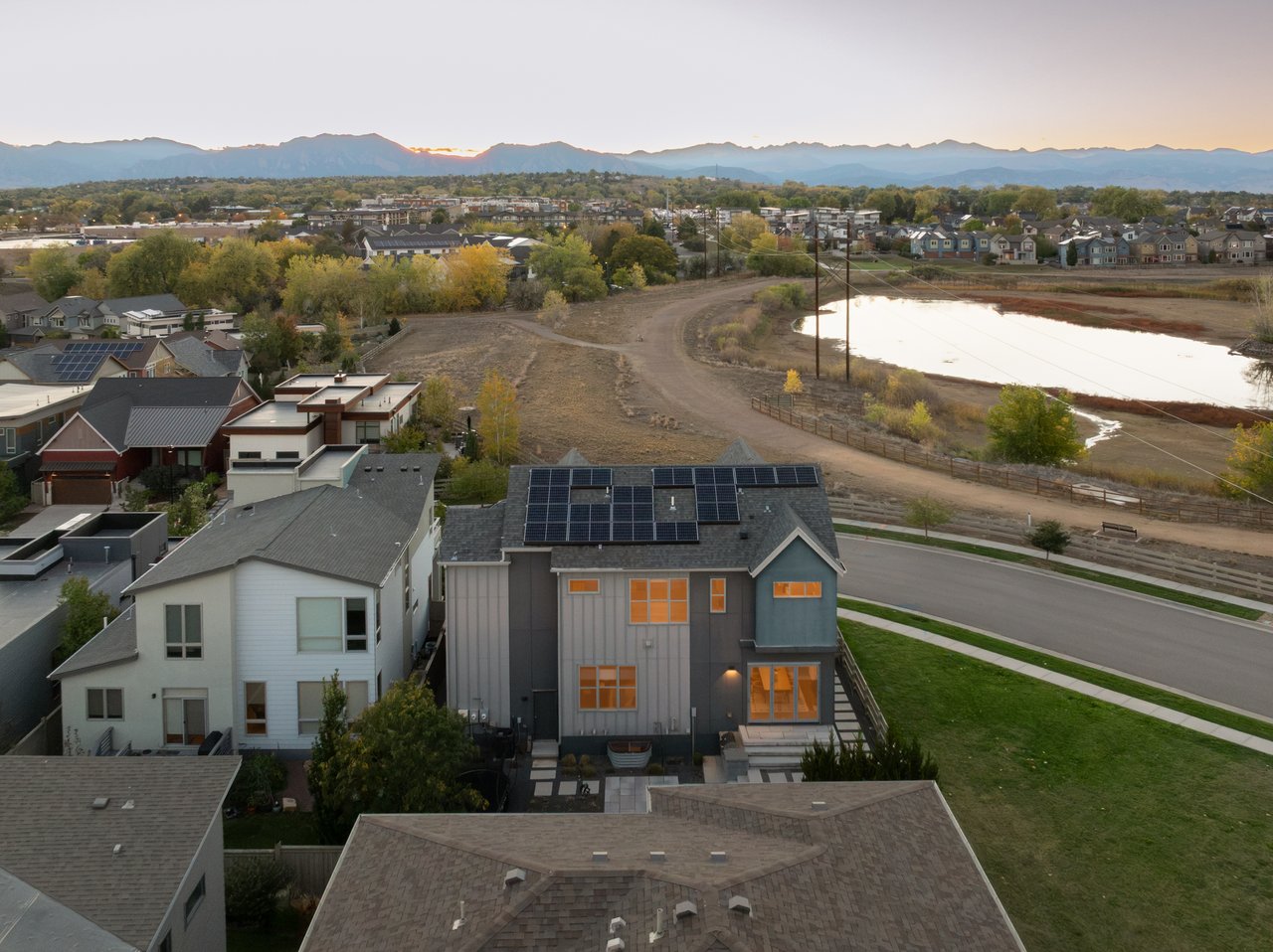 Aerial view of the home with the lake across the street and mountains on the horizon