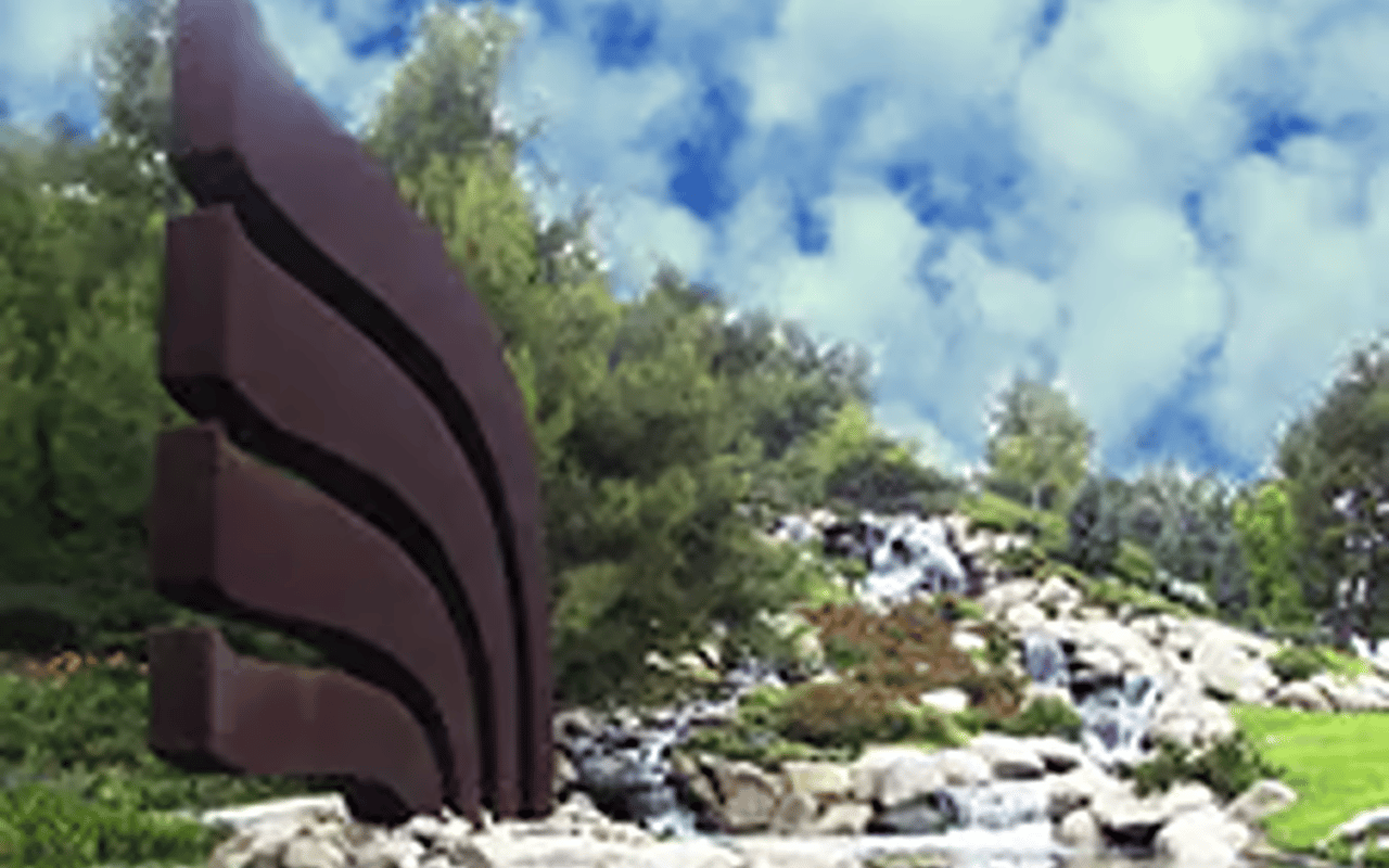 Redhawk community monument beside a landscaped rock waterfall.