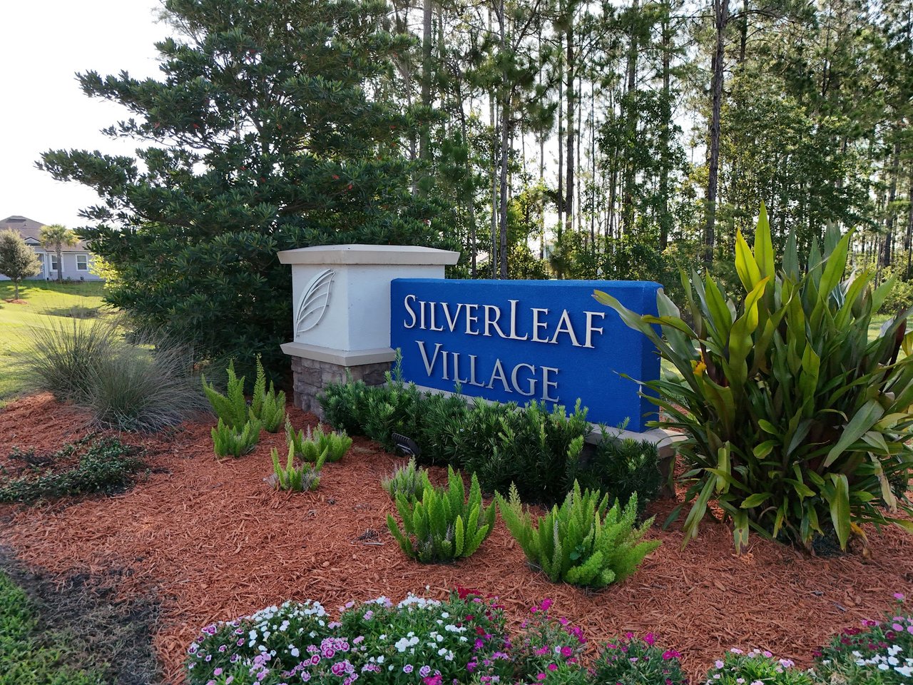 Silverleaf Village entrance sign surrounded by landscaping and trees.