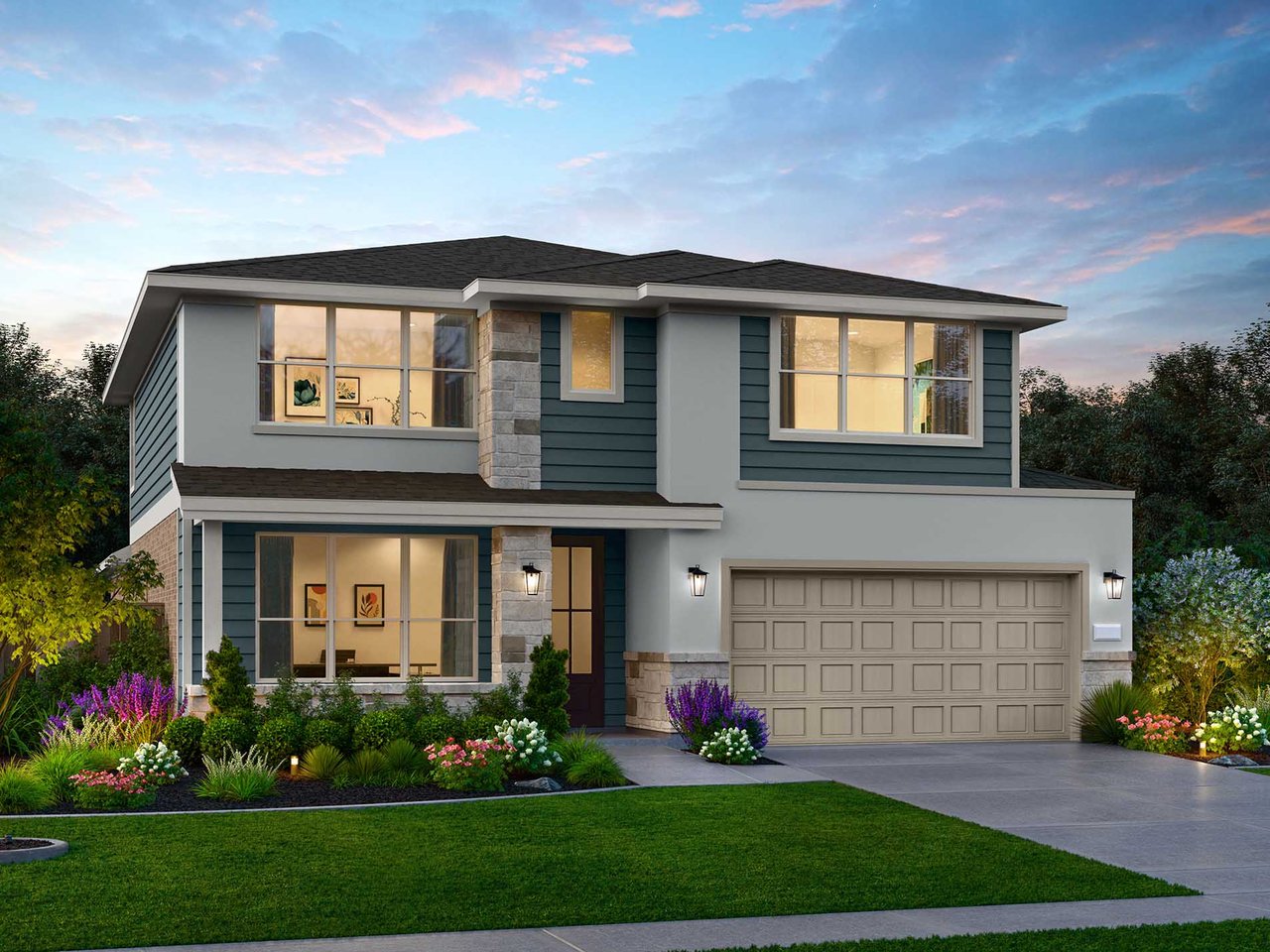 Two-story blue-gray house with stone accents, a double garage, and landscaped flower beds at dusk.