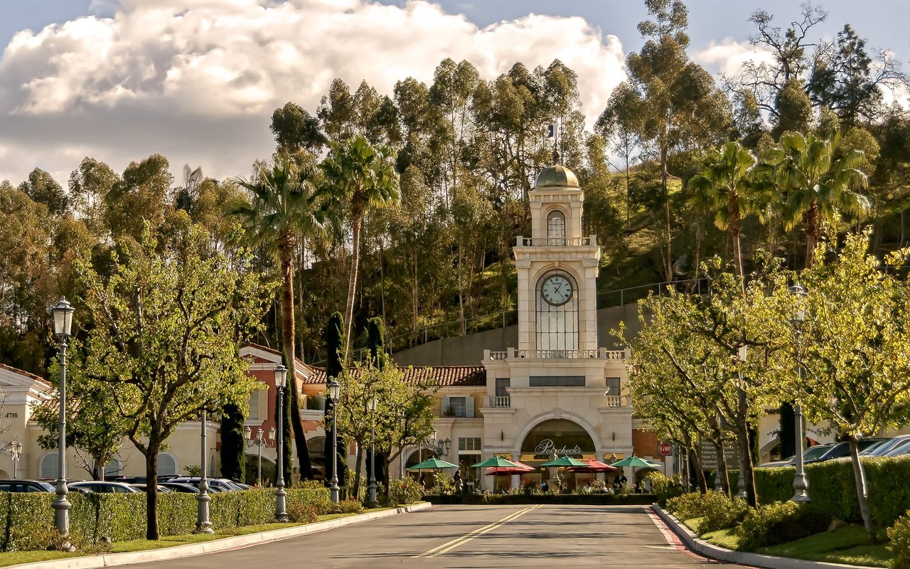 Calabasas shopping center with a prominent clock tower, palm trees and storefronts.
