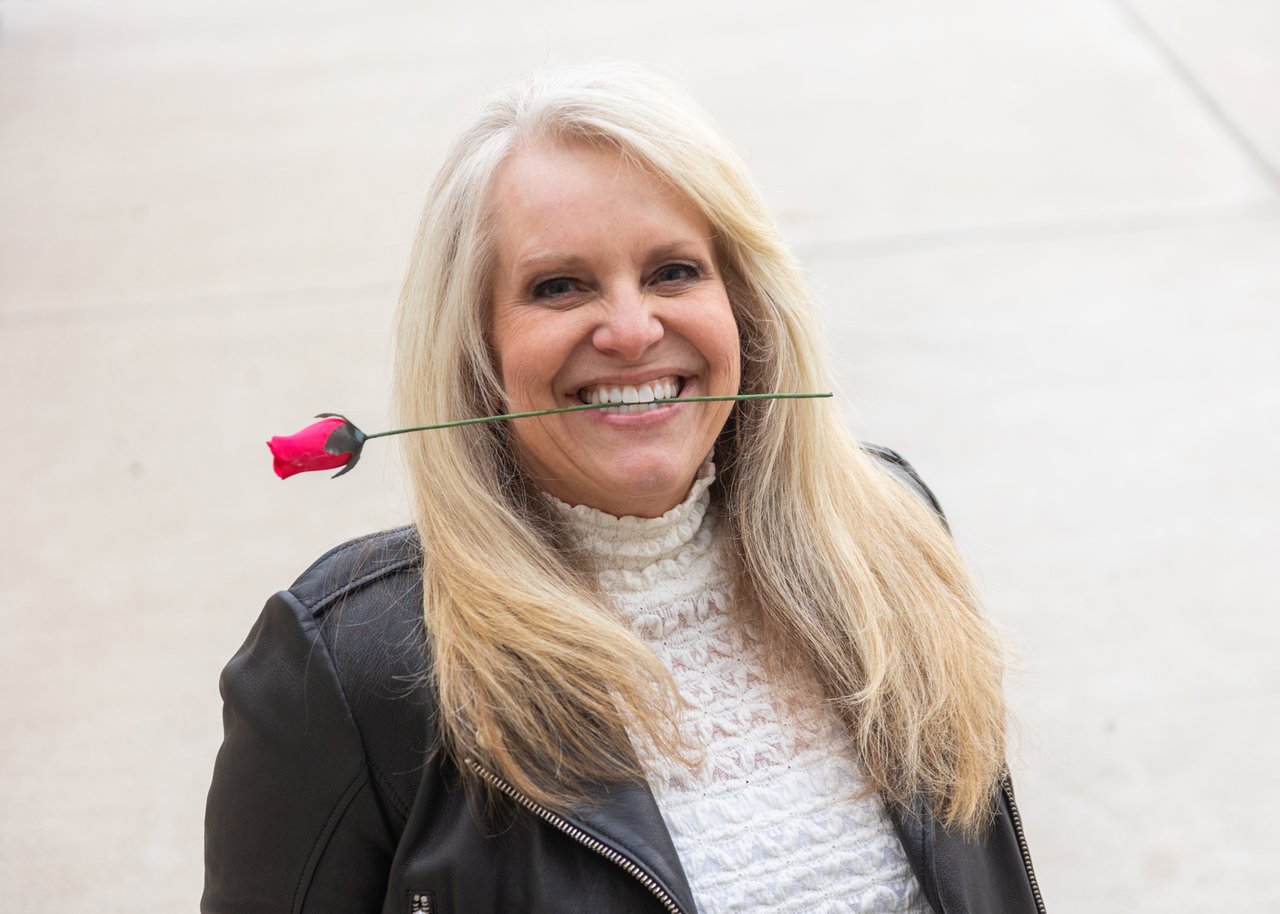 Sharla Ellis holding a rose, representing love, trust, and new possibilities in homeownership and mortgage guidance.