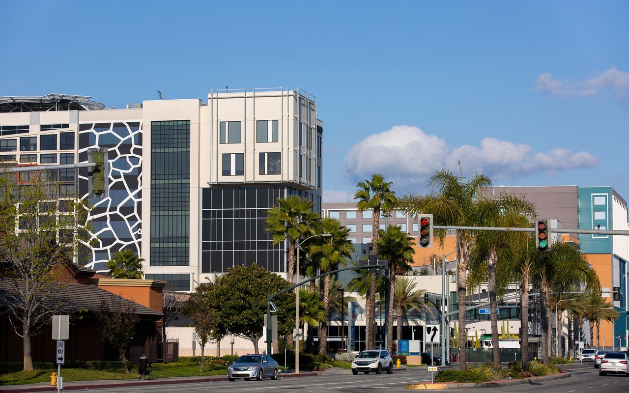 Buena Park commercial district with modern buildings, palm trees, and a busy street.