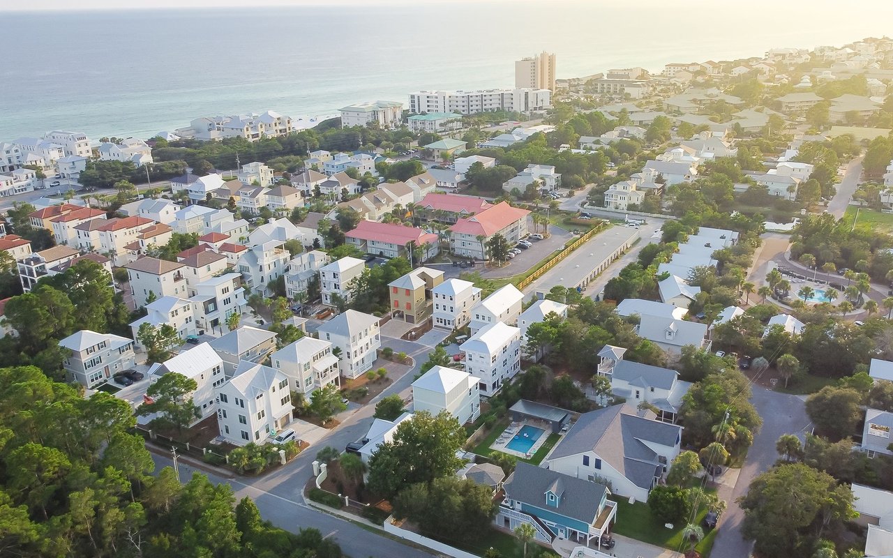 Aerial coastal neighborhood of homes beside the beach and ocean.