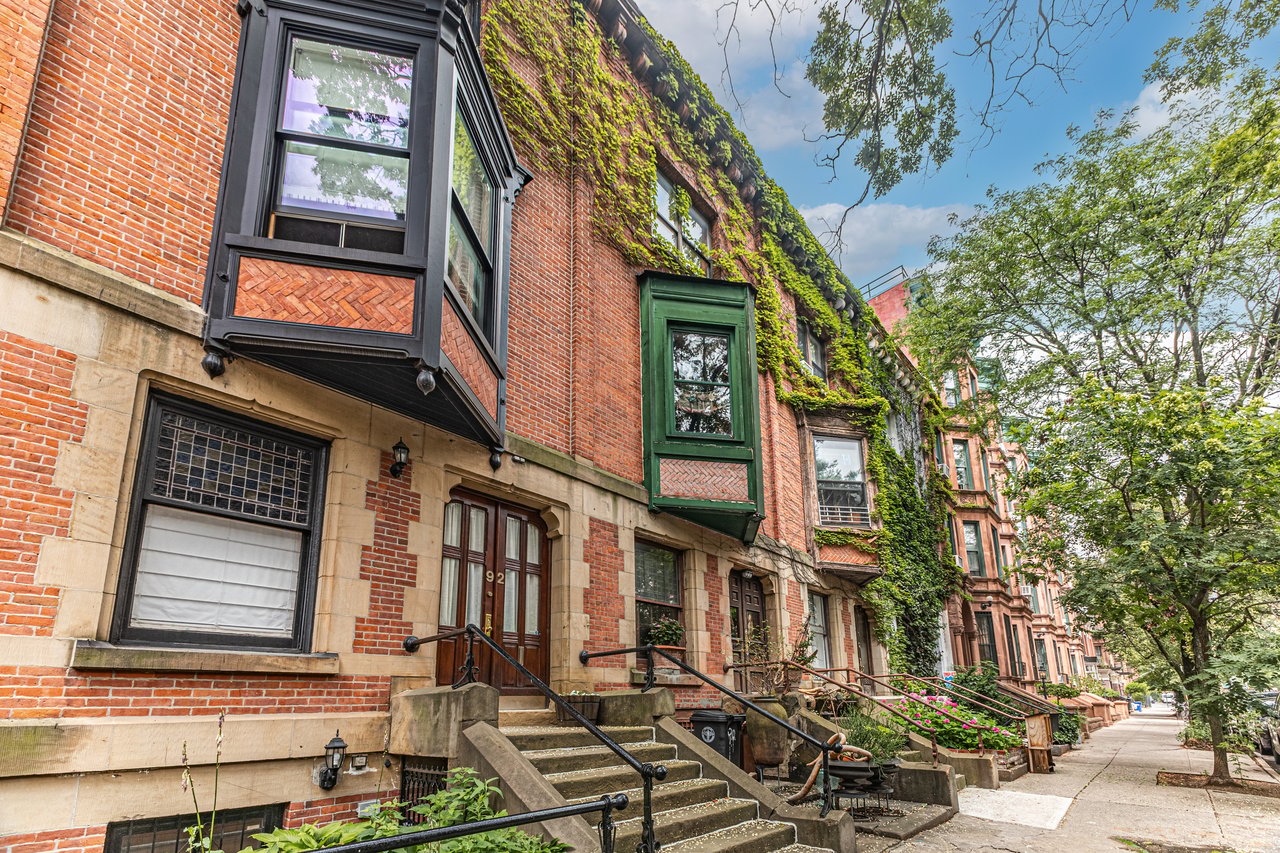 Historic brownstones, townhouses, multifamily homes, and neighborhood businesses along Lewis Avenue in Bedford-Stuyvesant, Brooklyn.