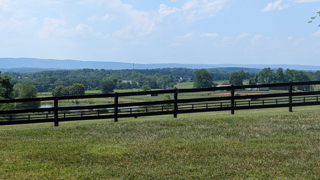 Scenic view of rolling hills and a black horse fence in the luxury countryside of Western Loudoun County, VA.