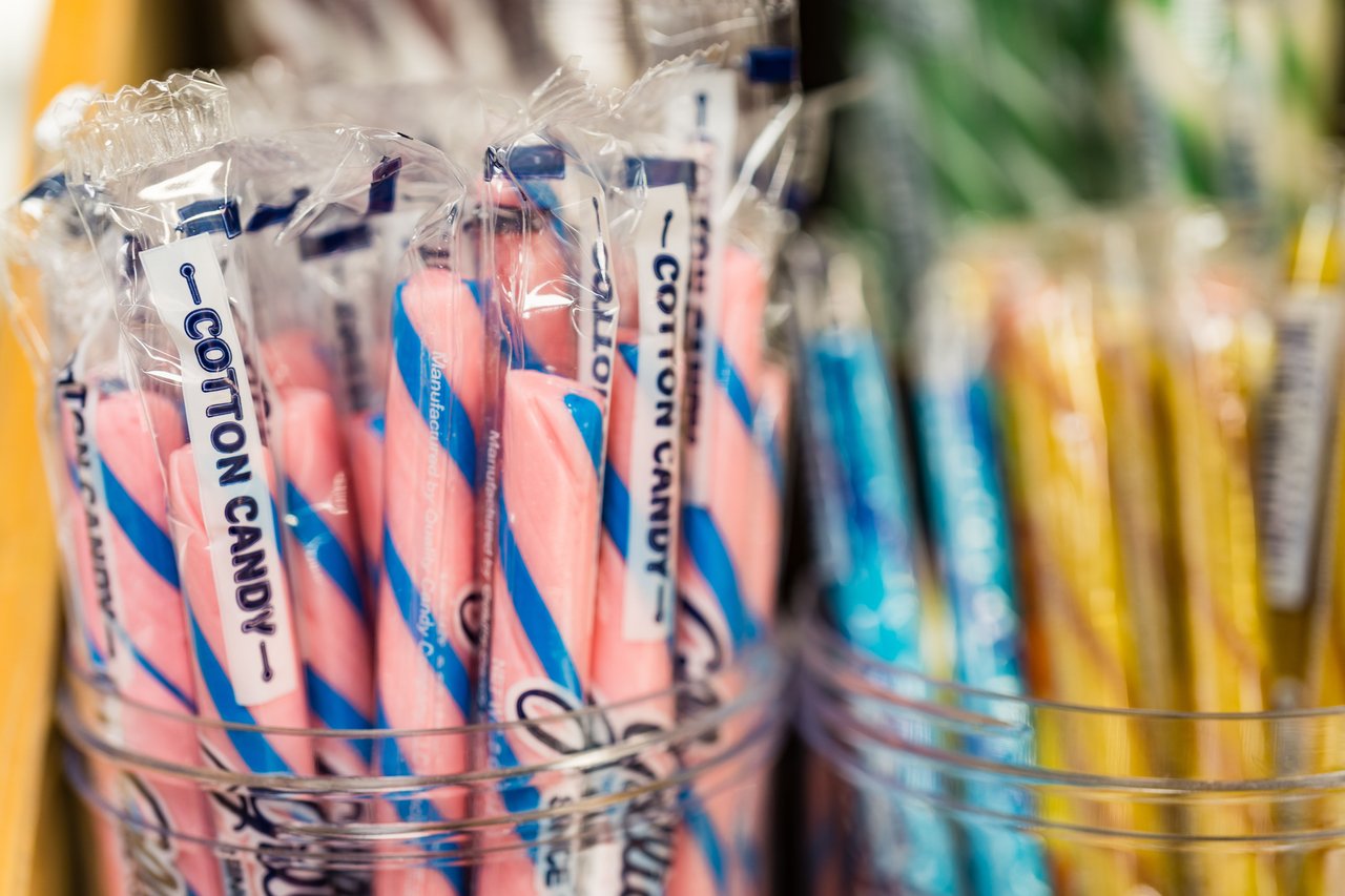 Wrapped pink-and-blue cotton candy sticks in clear display containers.