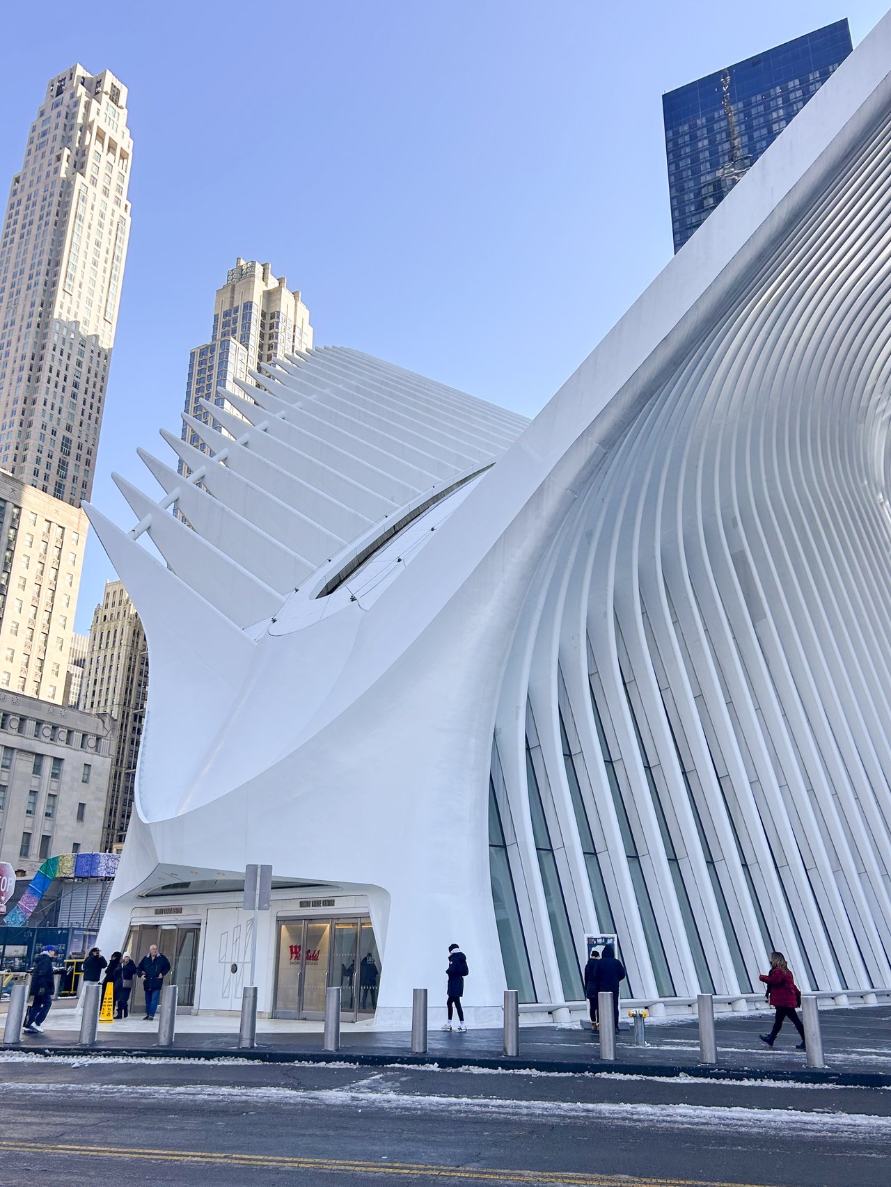 Parents and adult child standing together outside a New York City apartment building