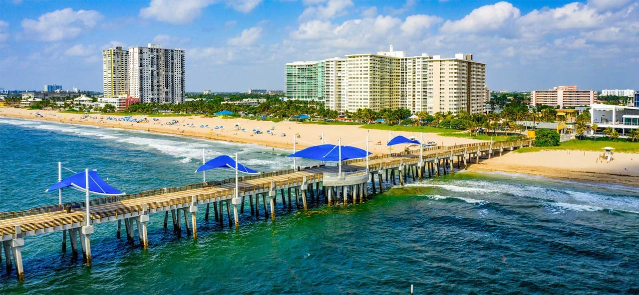 Pompano Beach Pier with blue canopies extending over the ocean in Pompano Beach, Florida.