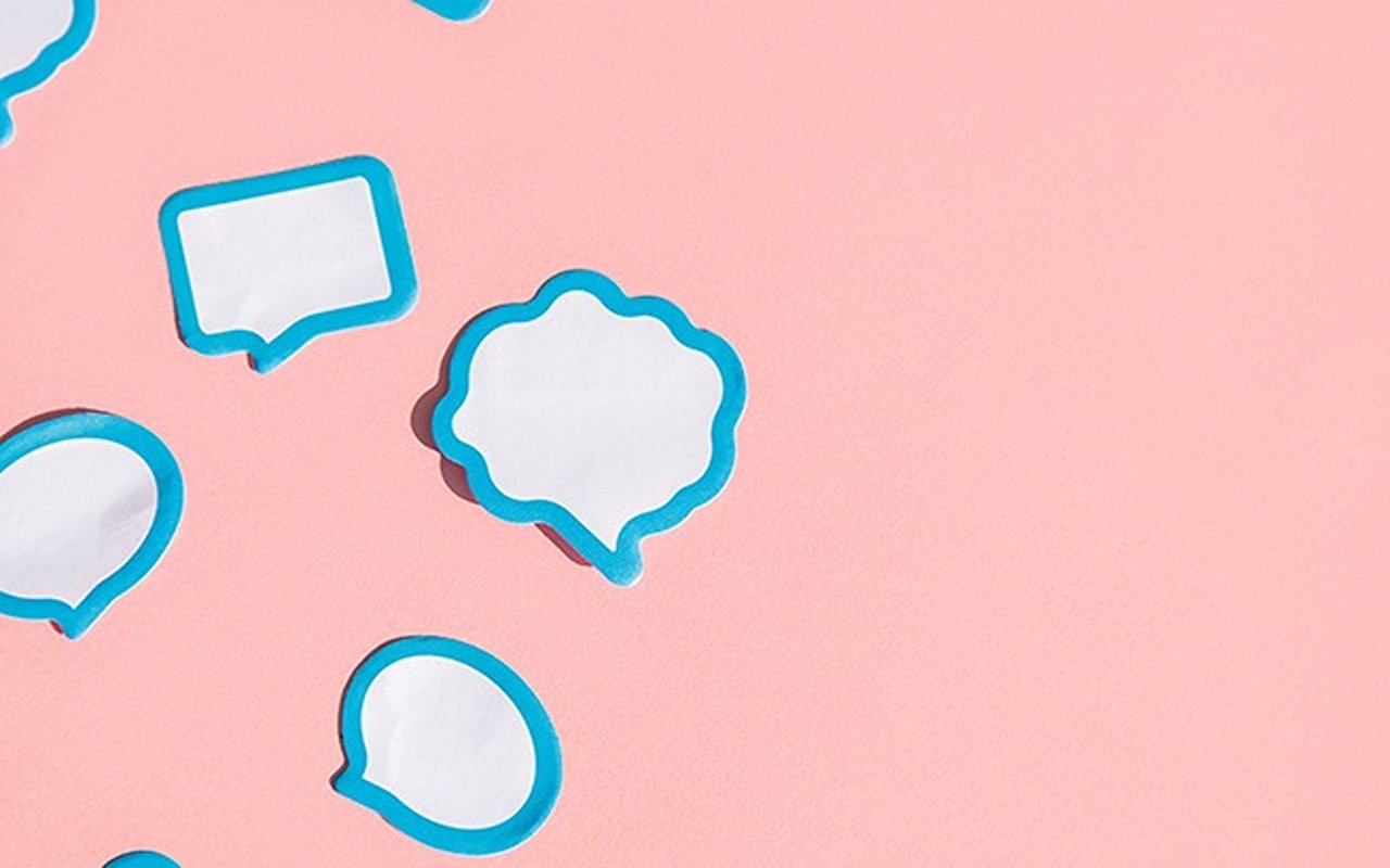 Blank blue-outlined speech bubbles scattered across a pink surface.