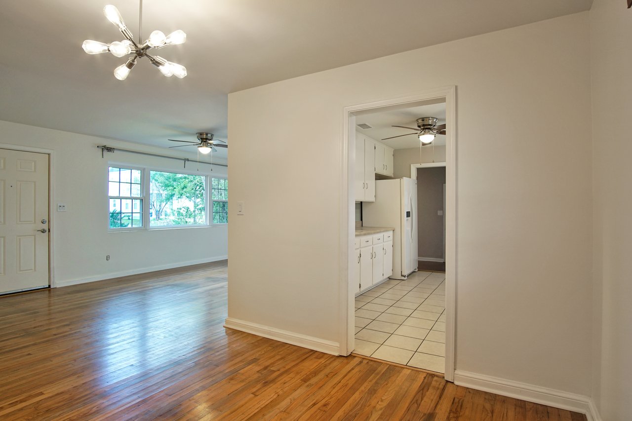 A spacious room featuring elegant hardwood floors and pristine white walls, creating a bright and inviting atmosphere.