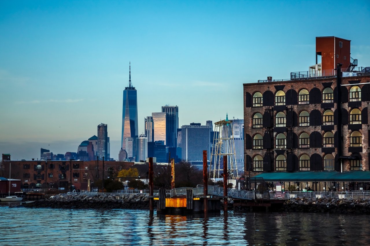 Red Hook waterfront and brick warehouse with the Lower Manhattan skyline across the water.