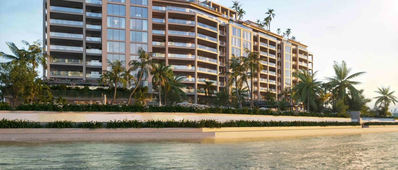 The Residences at Six Fisher Island, a palm-lined waterfront condominium with glass balconies.