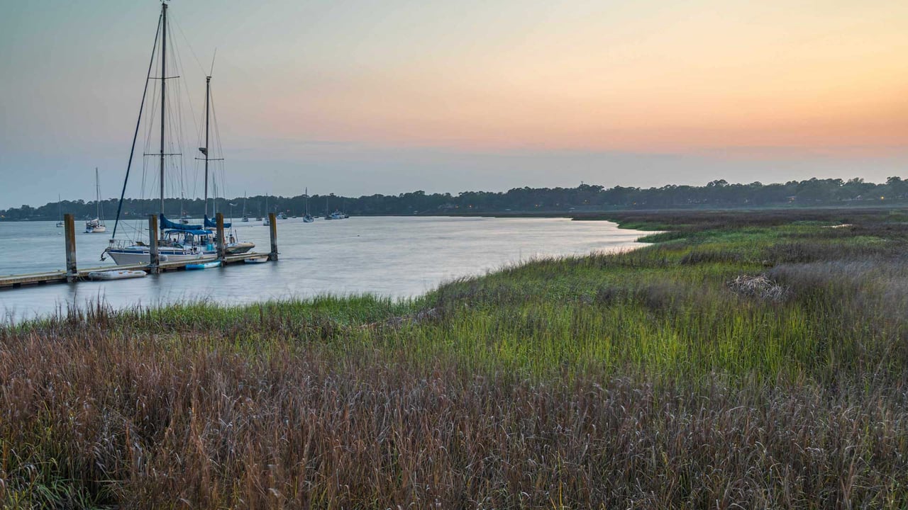 Sailboats docked at a marina on Johns Island at sunset