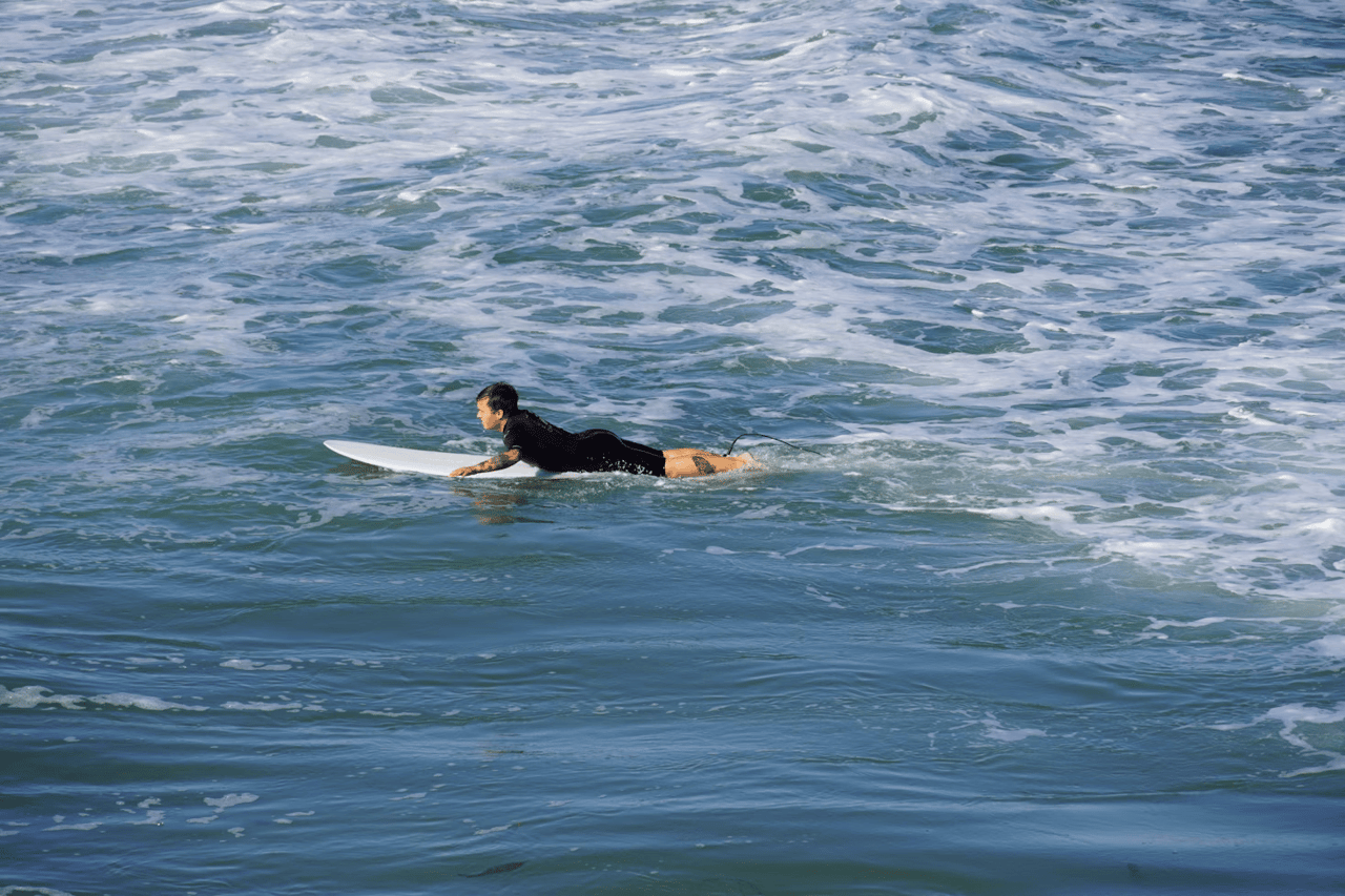 San Diego coastline in summer, capturing outdoor activities like paddleboarding and surfing in a refined, natural setting