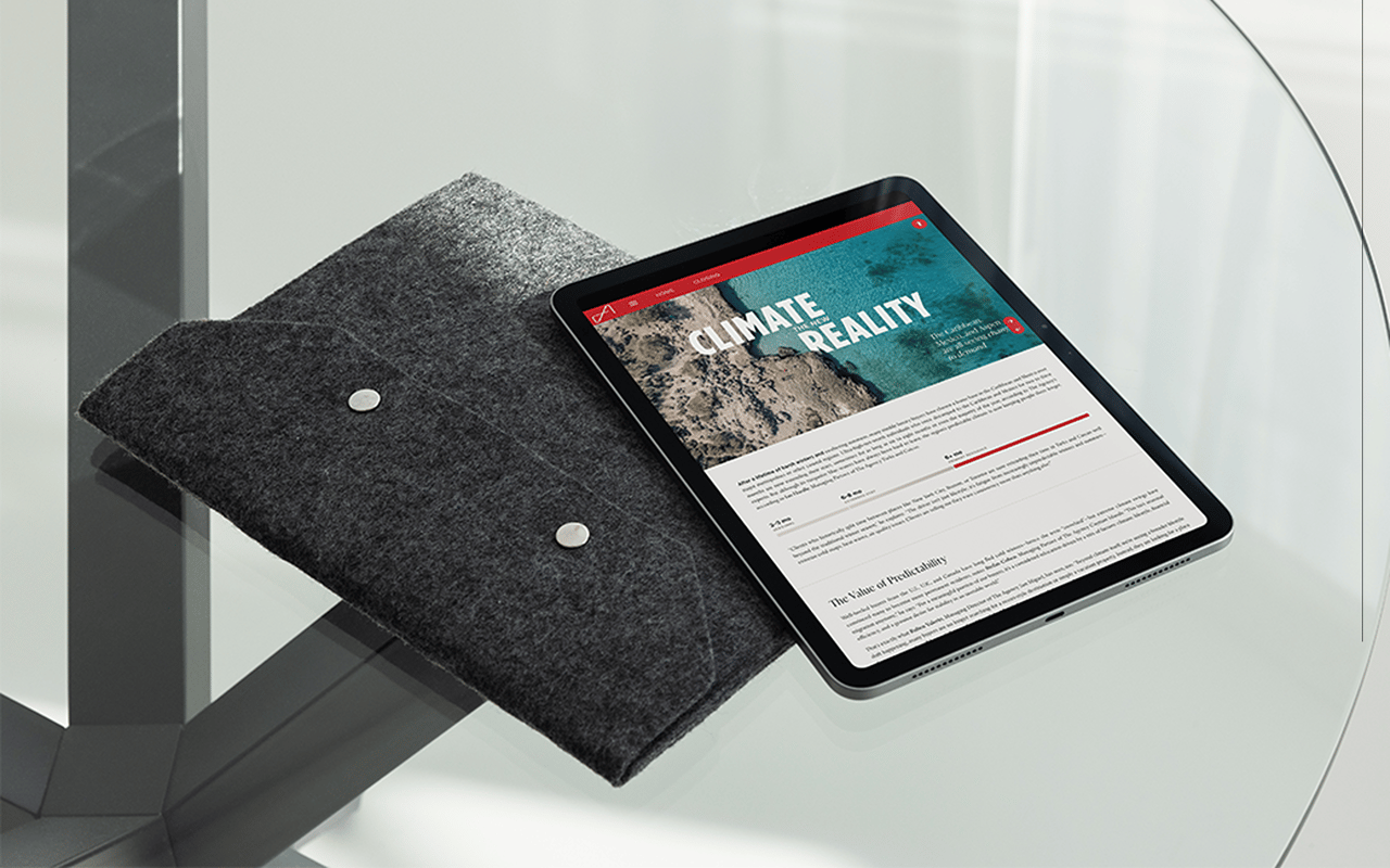 A tablet displaying a Climate Reality report rests on a dark felt chair.