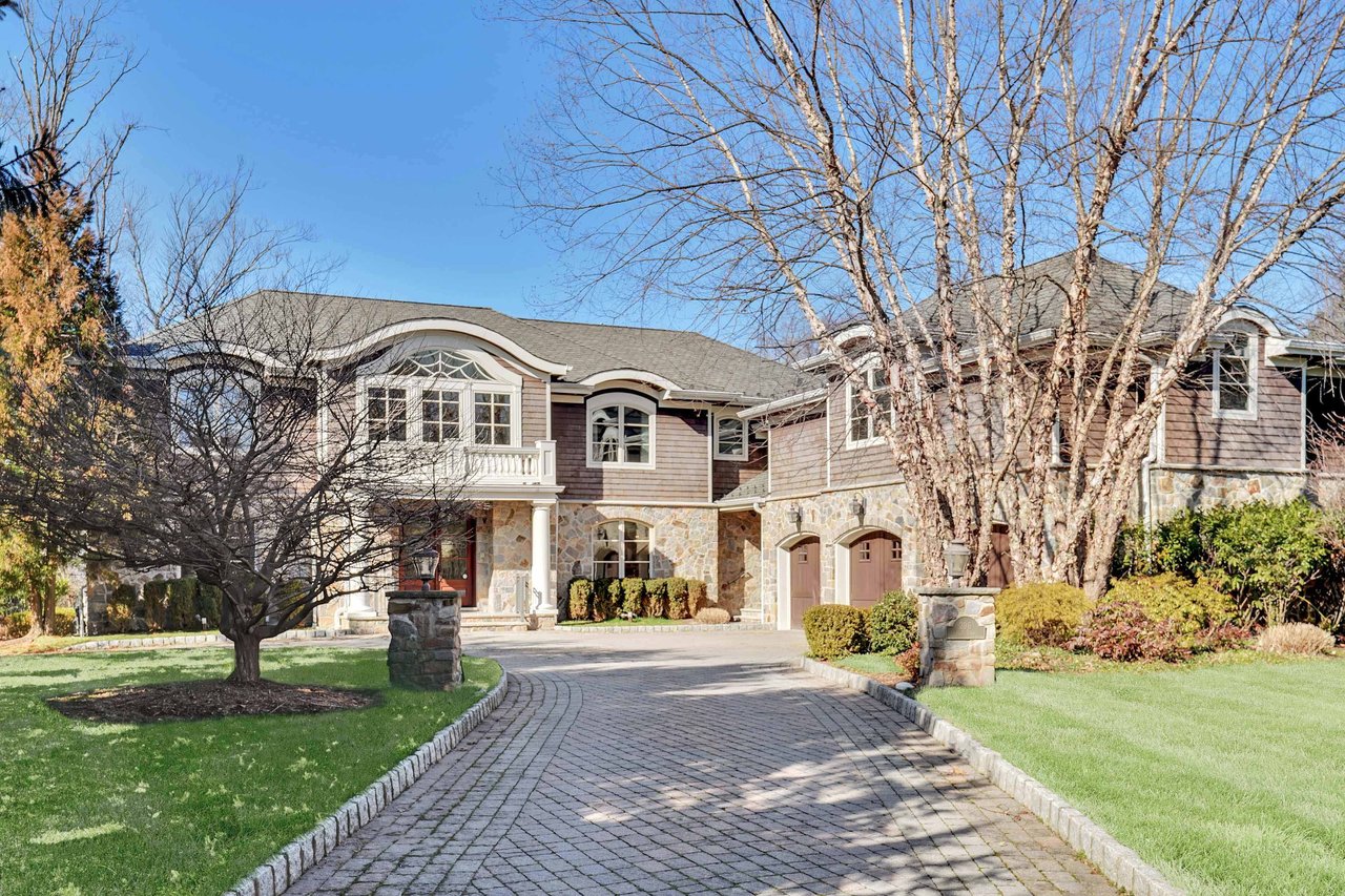 Large home with light brown stone face with three car garage