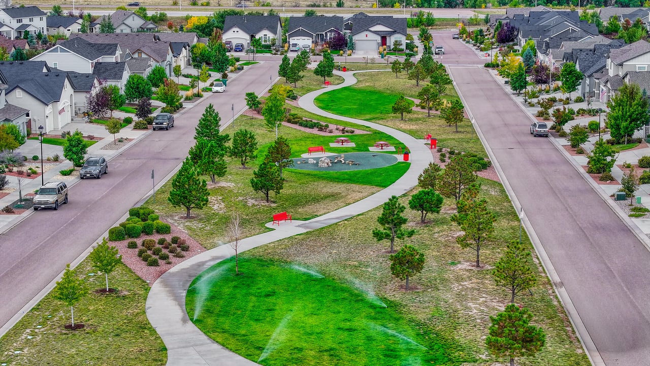 Aerial view of a neighborhood park with walking path and lawn