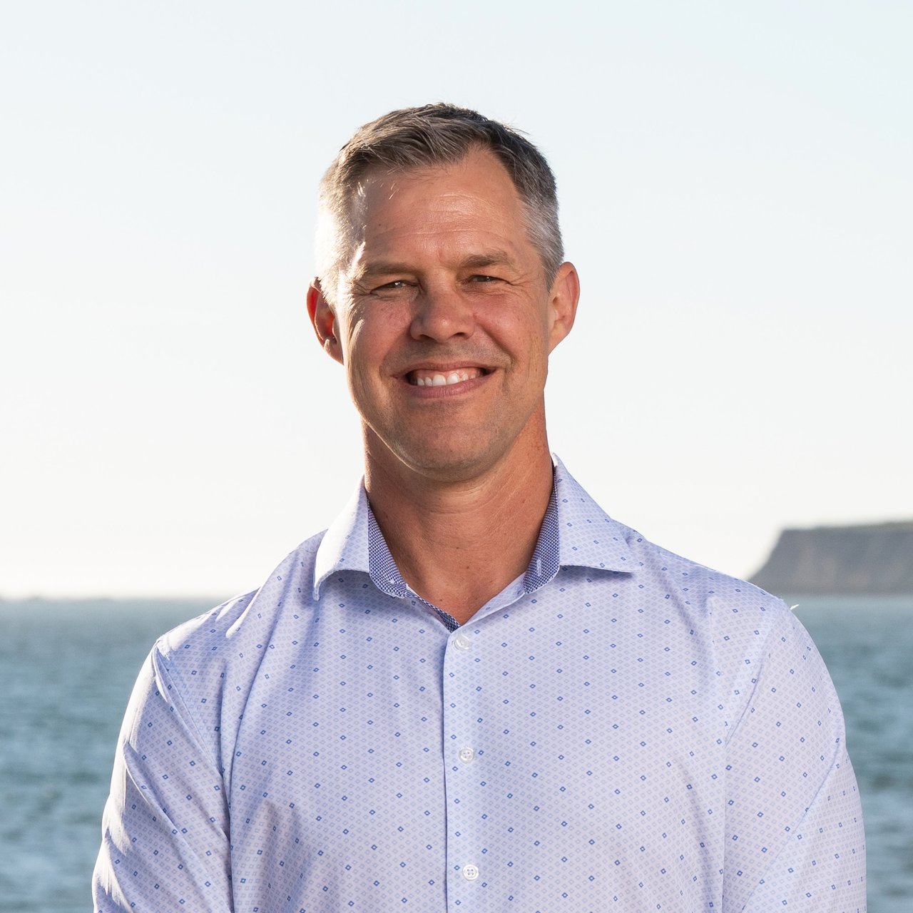 Joakim Bye, Half Moon Bay real estate agent with Ocean Element Real Estate, standing on a Coastside beach with ocean views in San Mateo County