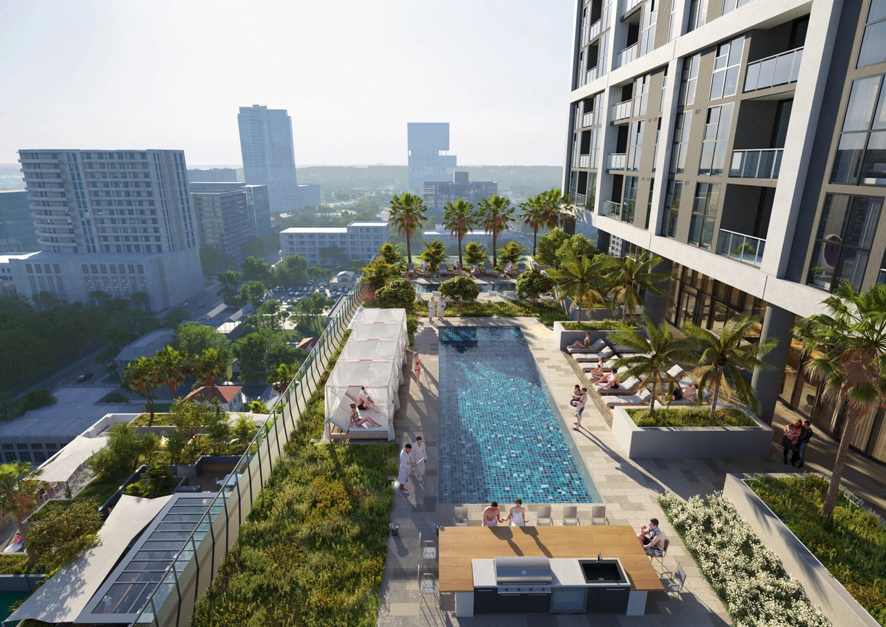 Condominium rooftop pool deck with cabanas, palm trees, and a city view.
